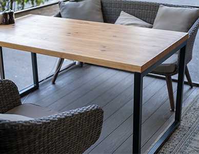 Minimalistyczny stolik o konstrukcji ramowej z pięknym, grubym, drewnianym blatem.
